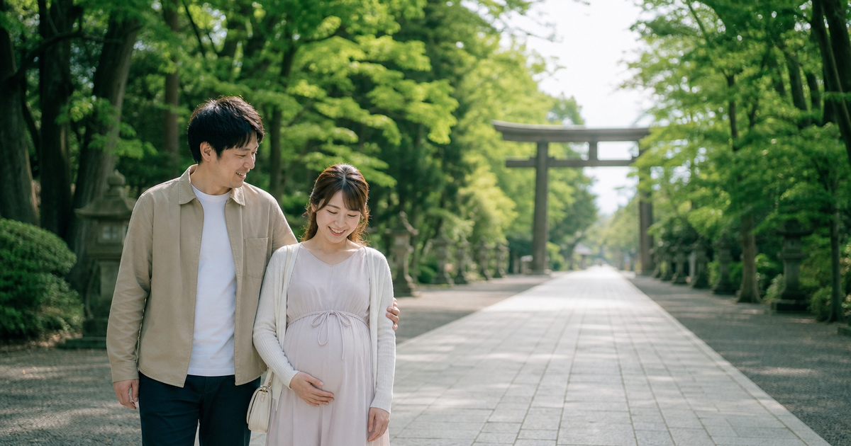 木々に囲まれた神社の参道を寄り添って歩く妊婦さんと夫